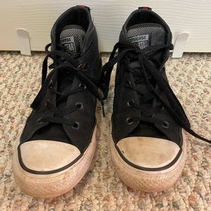 Black high top converse all stars with red accents.